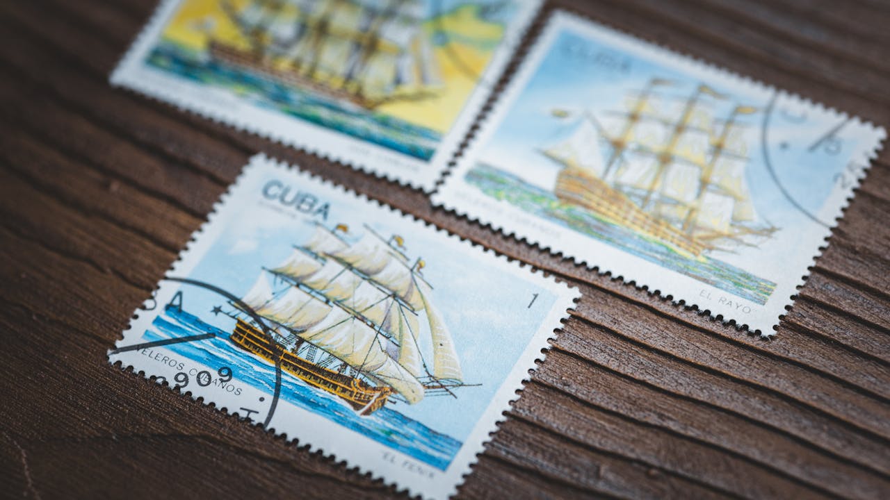 The Art of Drawing Readers In: Your attractive post title goes here Close-up of vintage Cuban postage stamps displaying sailing ships on a wooden background.